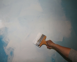 application couche de peinture chaux sur le mur bleu